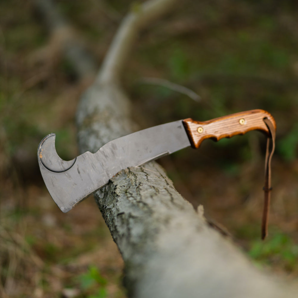 A Woodman’s Pal machete chopping a downed tree limb. 